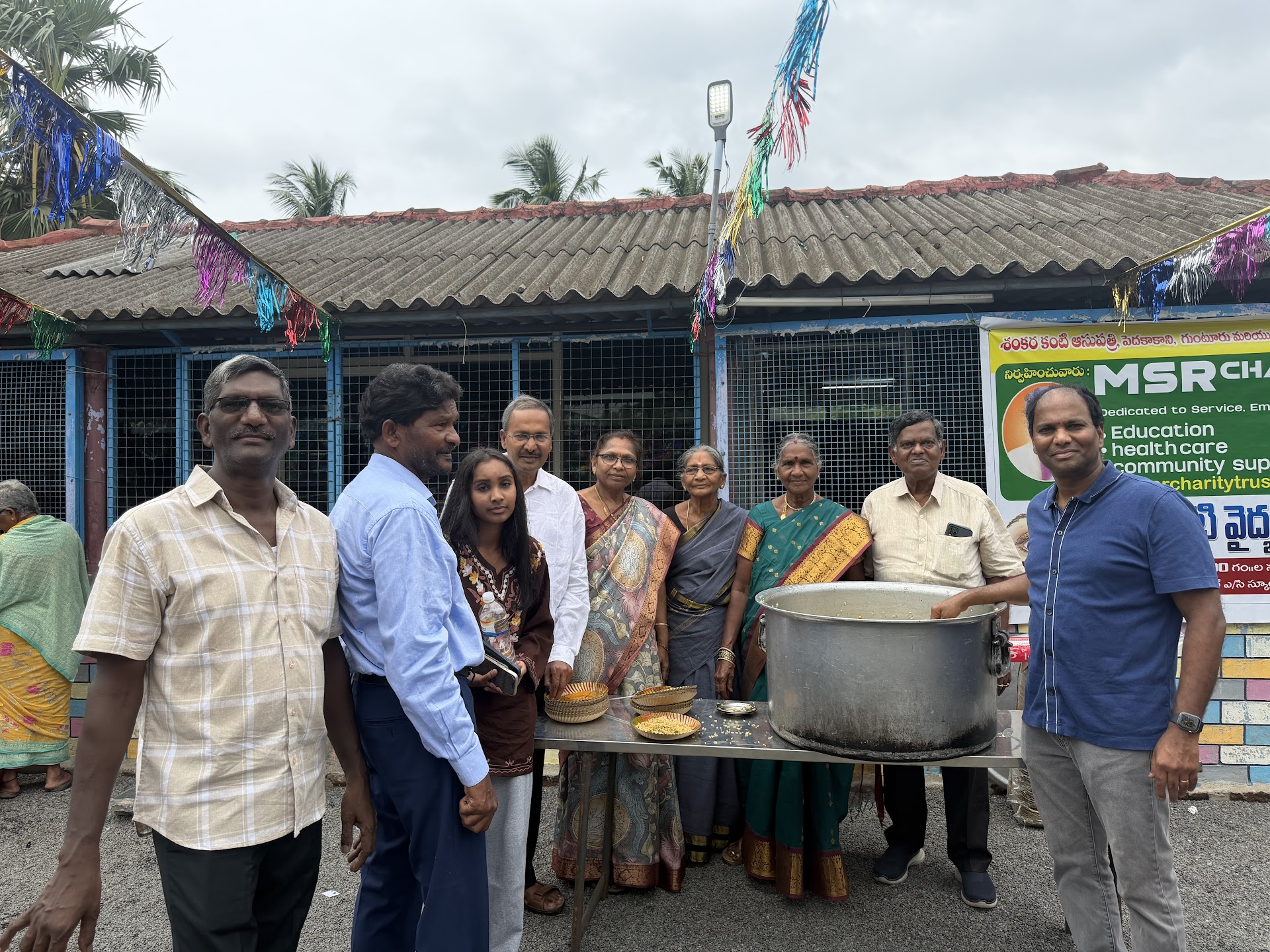Volunteers with a large pot at a food donation event organized by MSR Charitable Trust