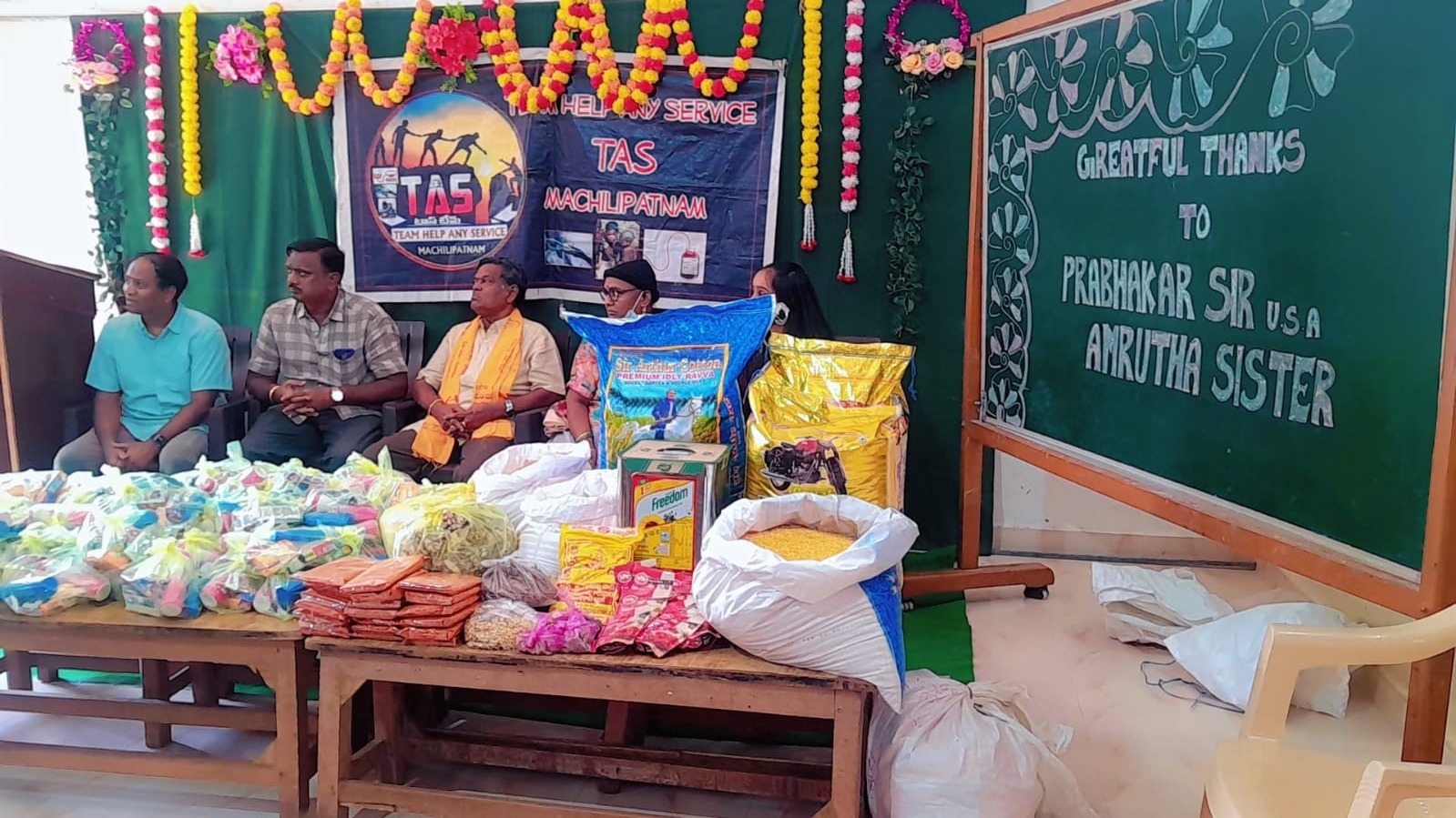 Food packets and supplies arranged on a table at a community food distribution event